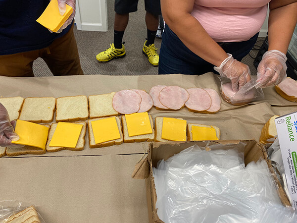 Covenant Home youth and community volunteering to help put together sandwiches for homeless youth