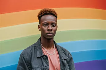 gay teen in front of rainbow wall | Covenant Home