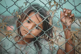 trafficked girl behind fence | Covenant Home - Know the Issues - Human Trafficking