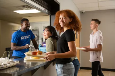 Young lady receiving food in a Covenant Home Cafeteria