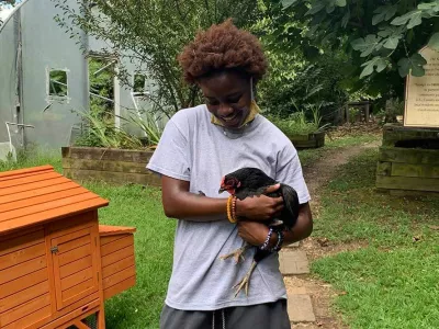 Covenant Home resident Ann holding a chicken in a yard