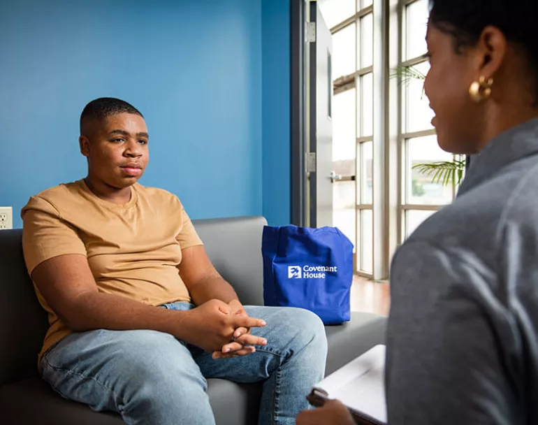 Young man sitting and talking to a Covenant Home staff